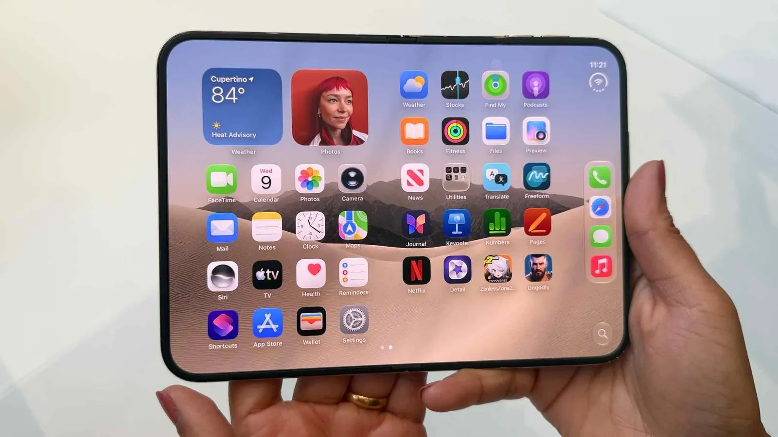 Gri tonlu stüdyo ortamında hafif aralık duran katlanabilir iPhone Duo modeli
