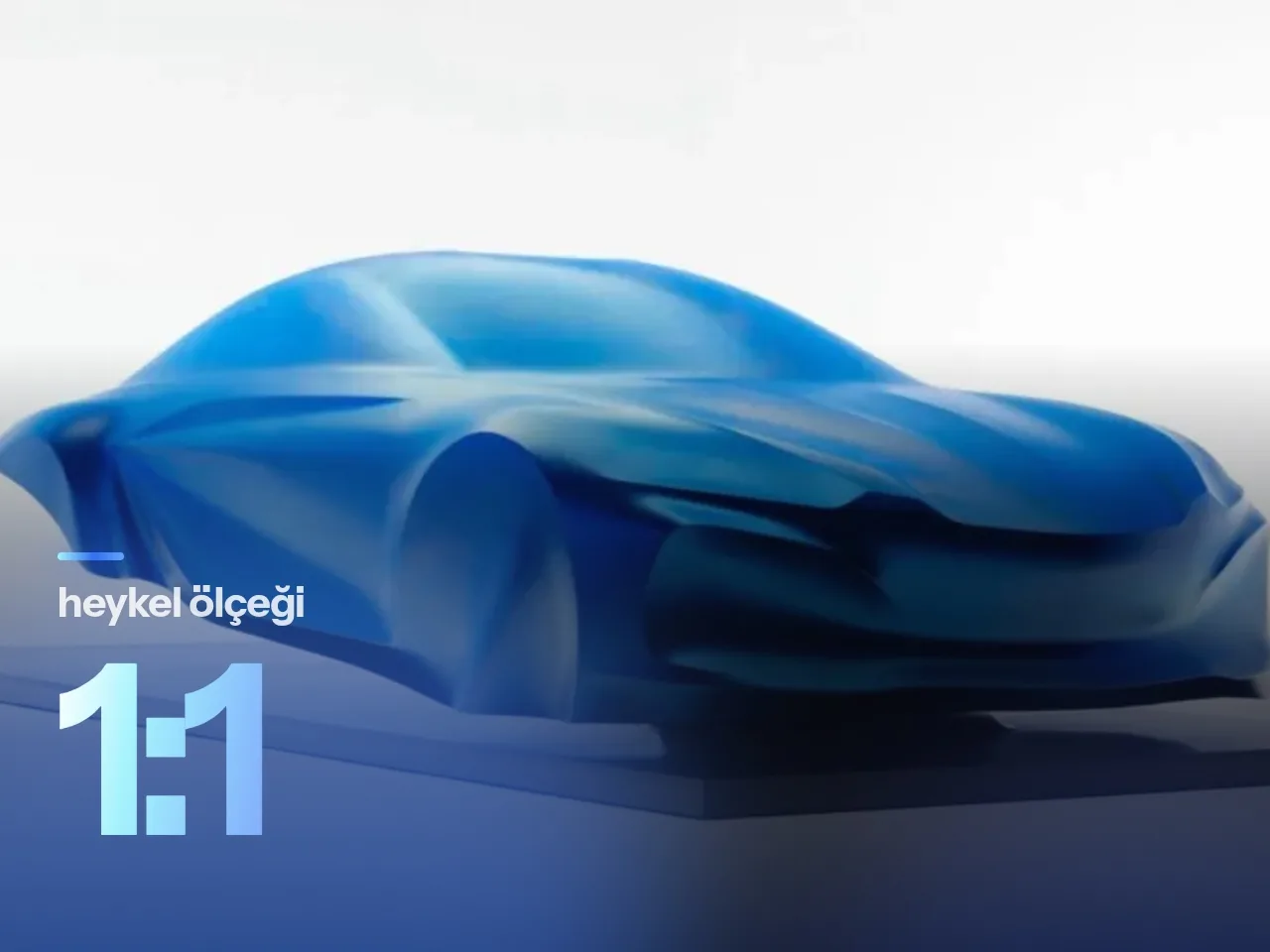 Mavi ipek örtü altında sergilenen Alpine a110 konsept heykelinin stüdyo ortamındaki görünümü