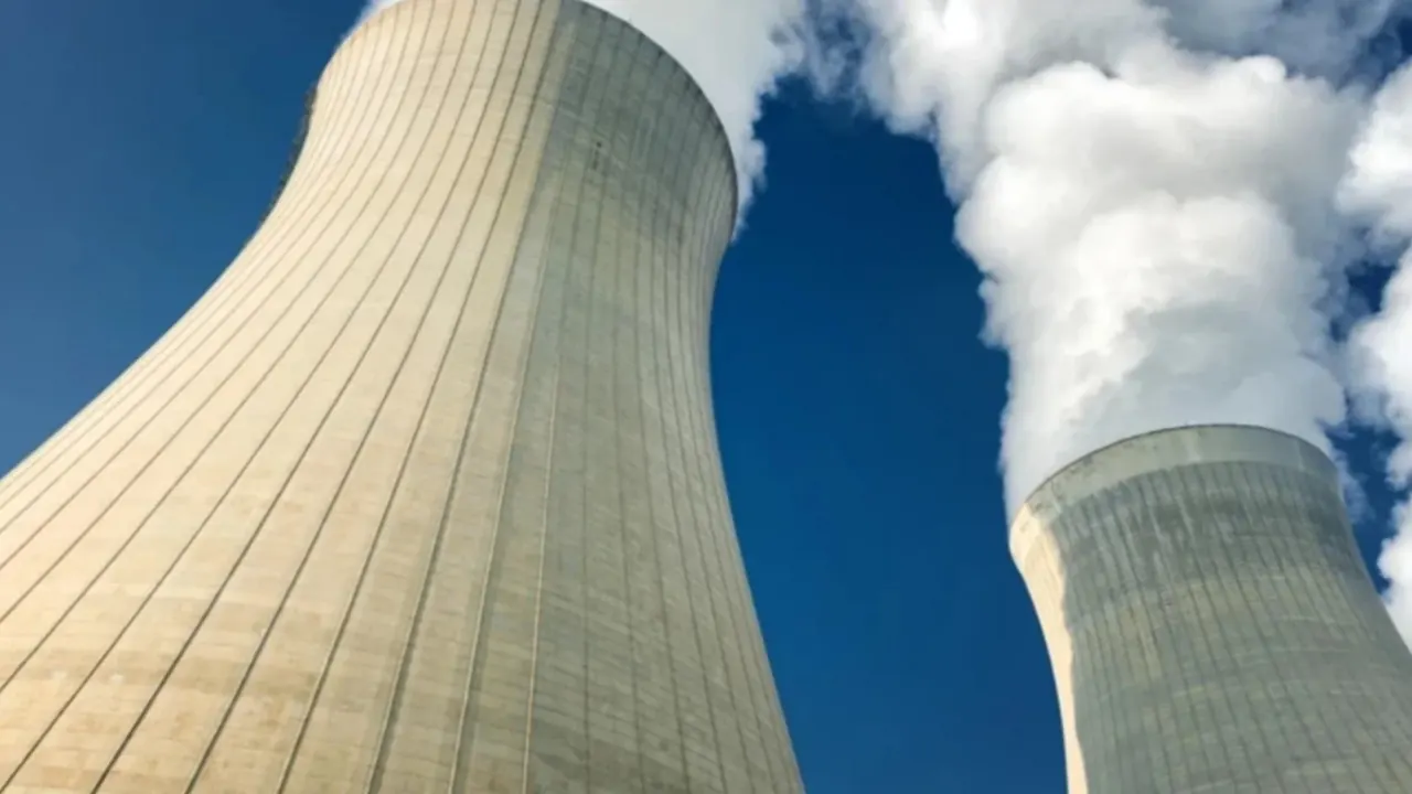 Nükleer santralleri ve dijital altyapıyı temsil eden modern, camdan yapılmış soyut enerji silindirleri.
