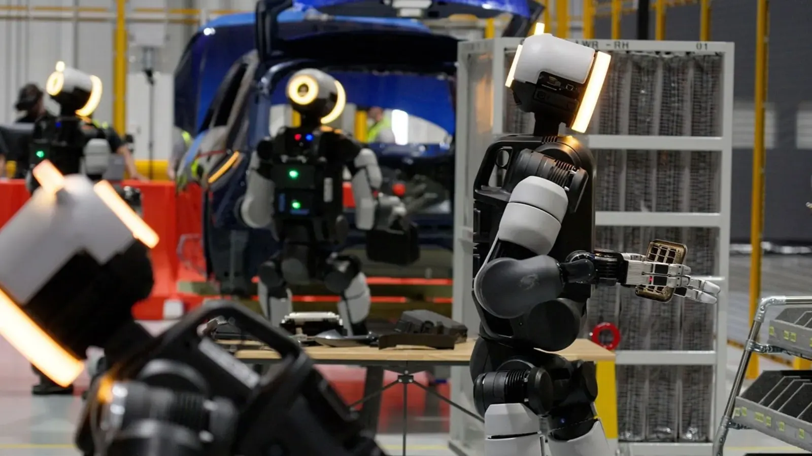 Hyundai fabrikasında görev yapan, metalik bir yüzeye sahip insansı robot Atlas'ın çalışma anını yansıtan görsel.